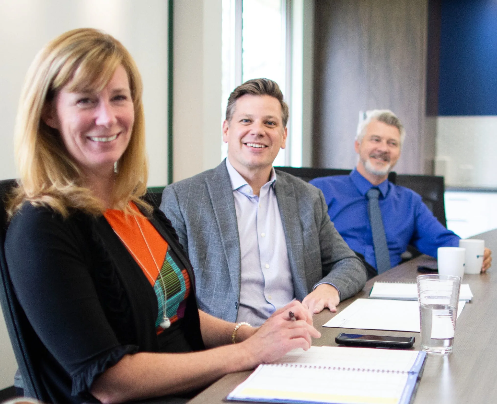 A group of people sitting at a board table.